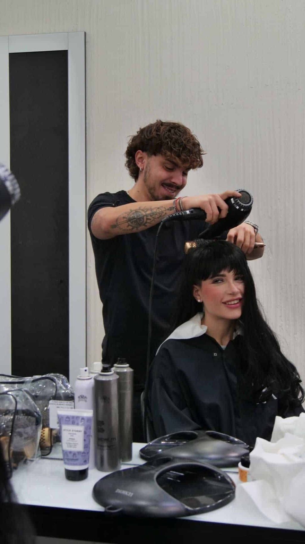 A hairdresser styles the hair of a model.