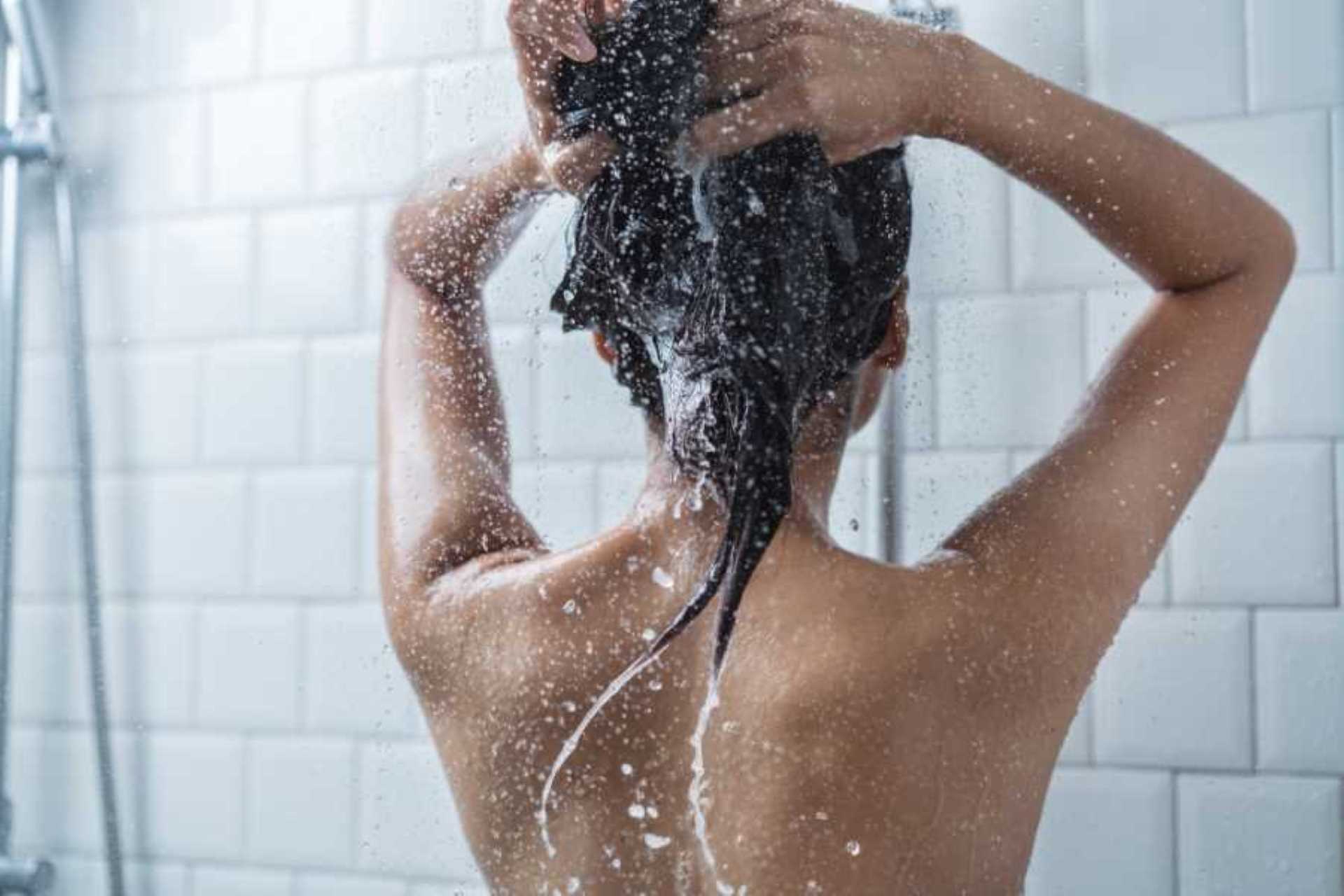 Frau beim Haarewaschen mit einem Haarpflegeprodukt gegen Haarausfall von Hairdreams