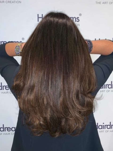 Nach einer Haarverlängerung mit Hairdreams-Extensions bei einer Frau mit schwarzen Haaren
