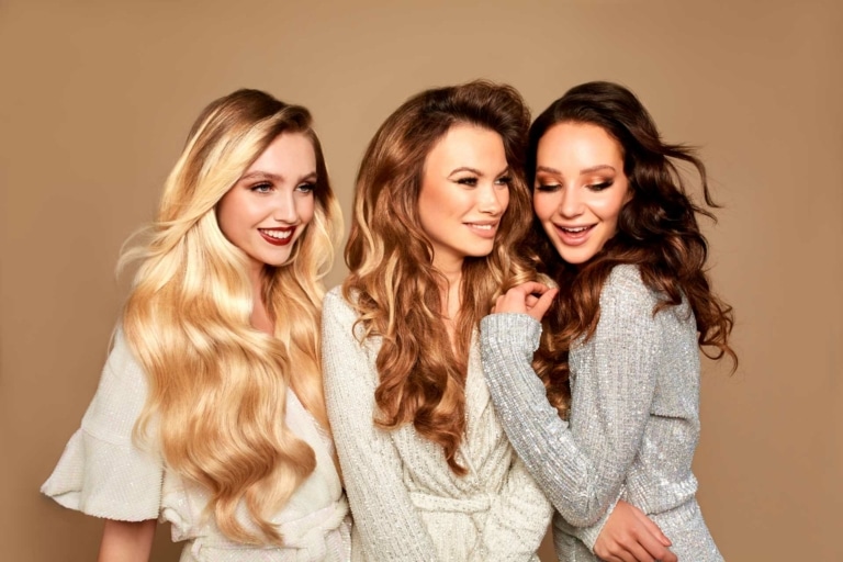 Drei Frauen mit blonden, hellbraunen und dunkelbraunen Hairdreams Haarverlängerungen